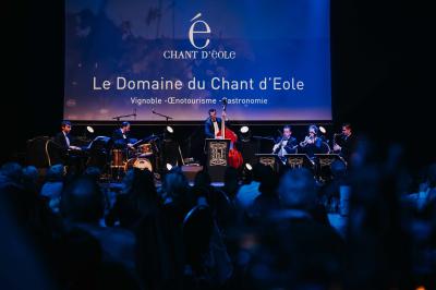 Rangées de chaises noires alignées dans une salle lumineuse avec une table en bois au premier plan.