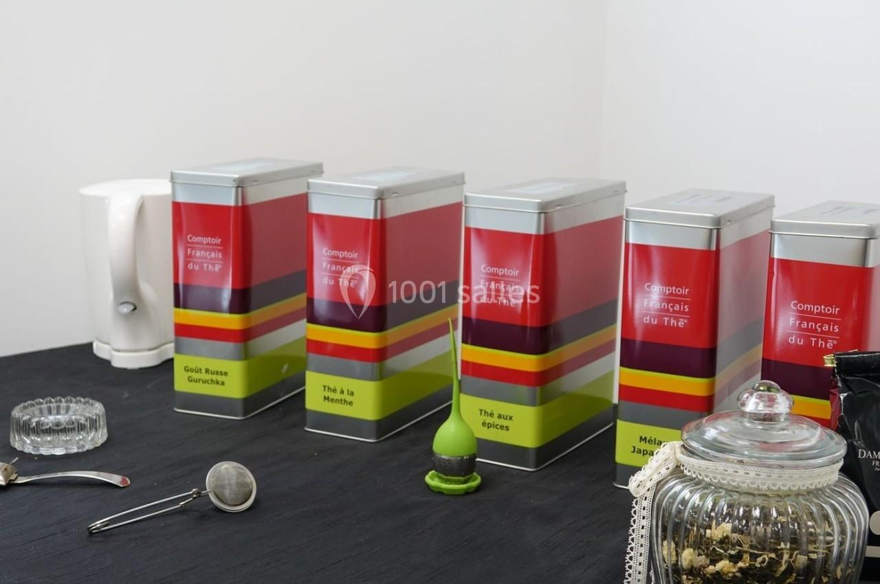 Boîtes de thé alignées sur une table noire avec divers accessoires pour la préparation du thé.
