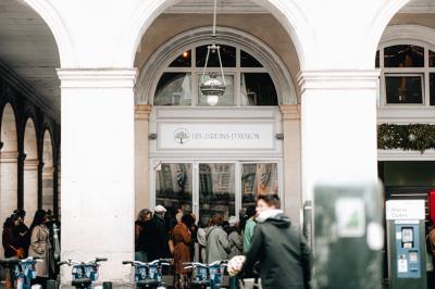 Bouteilles de bière variées alignées sur une étagère en bois devant un mur en pierre.