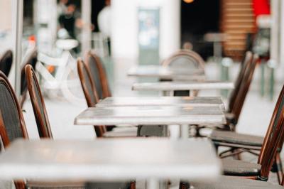 Bouteilles de bière variées alignées sur une étagère en bois devant un mur en pierre.