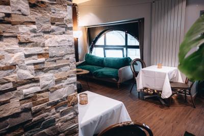 Bouteilles de bière variées alignées sur une étagère en bois devant un mur en pierre.