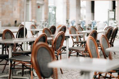 Bouteilles de bière variées alignées sur une étagère en bois devant un mur en pierre.