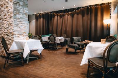 Bouteilles de bière variées alignées sur une étagère en bois devant un mur en pierre.