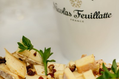 Serviettes blanches roulées posées sur un lit avec des oreillers et des draps blancs en arrière-plan.