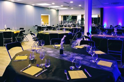 Serviettes blanches roulées posées sur un lit avec des oreillers et des draps blancs en arrière-plan.