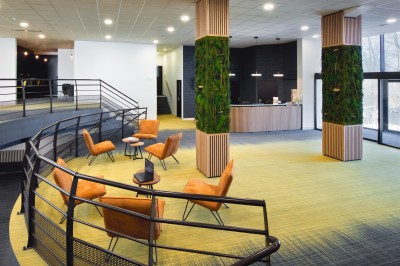 Serviettes blanches roulées posées sur un lit avec des oreillers et des draps blancs en arrière-plan.