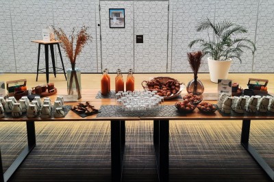 Serviettes blanches roulées posées sur un lit avec des oreillers et des draps blancs en arrière-plan.