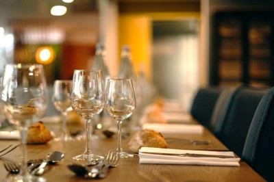 Serviettes blanches roulées posées sur un lit avec des oreillers et des draps blancs en arrière-plan.