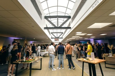 Serviettes blanches roulées posées sur un lit avec des oreillers et des draps blancs en arrière-plan.