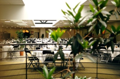 Serviettes blanches roulées posées sur un lit avec des oreillers et des draps blancs en arrière-plan.