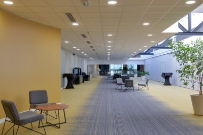 Serviettes blanches roulées posées sur un lit avec des oreillers et des draps blancs en arrière-plan.