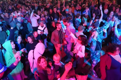 Miniature DJ Milizac (Finistère) - Florian Rion #10 Homme en chemise noire, lunettes de soleil, fumant un cigare, tenant un verre devant un bar rempli de bouteilles.