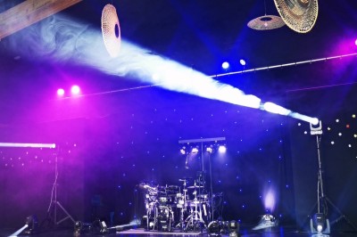 Miniature DJ Milizac (Finistère) - Florian Rion #12 Homme en chemise noire, lunettes de soleil, fumant un cigare, tenant un verre devant un bar rempli de bouteilles.