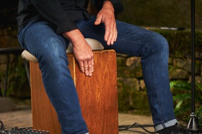 Miniature DJ Milizac (Finistère) - Florian Rion #21 Homme en chemise noire, lunettes de soleil, fumant un cigare, tenant un verre devant un bar rempli de bouteilles.