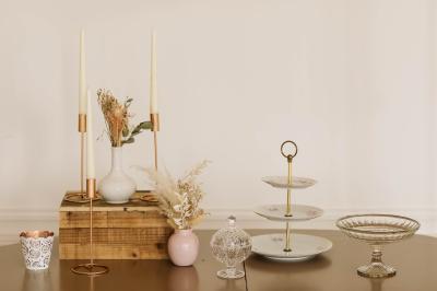 Salle de réception décorée avec des tables rondes, nappes blanches, chandeliers et compositions florales.