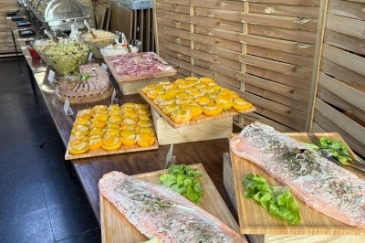 Miniature Traiteur Leers (Nord) - Tendance et Fraicheur Traiteur #16 Brochettes de viande et légumes grillant sur un barbecue en plein air, avec une fontaine et un jardin en arrière-plan.