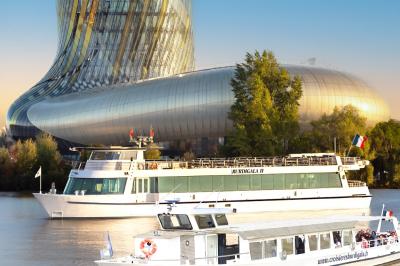 Miniature Les deux bateaux des Croisières Burdigala proche de la cité du vin Une main dépose une crêpe chaude sur une assiette à l'aide d'une spatule, près d'une crêpière en extérieur.