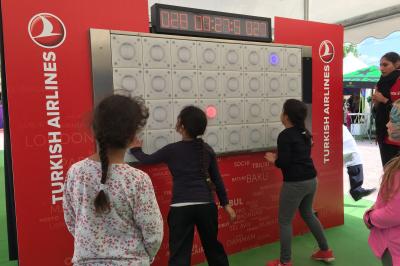 Miniature Mur interactif adapté aussi pour les enfants Mur interactif lumineux avec chronomètre, accessoires de sport et équilibre disposés sur deux tables bleues au premier plan.