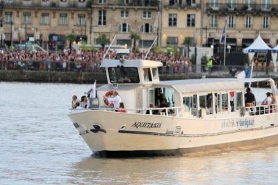 Bateau naviguant sur un fleuve devant un bâtiment historique avec une architecture classique.