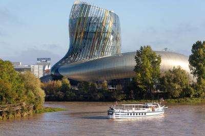 Bateau naviguant sur un fleuve devant un bâtiment historique avec une architecture classique.