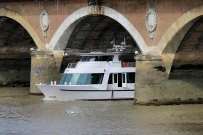 Bateau naviguant sur un fleuve devant un bâtiment historique avec une architecture classique.