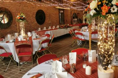 Miniature Location salle Libramont-Chevigny (Luxembourg) - Domaine du Château de Freux #10 Un couple en tenue de mariage se tient devant un officiant dans un décor festif avec sapins et guirlandes lumineuses.