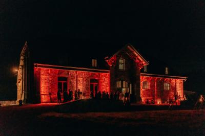 Miniature Location salle Libramont-Chevigny (Luxembourg) - Domaine du Château de Freux #13 Un couple en tenue de mariage se tient devant un officiant dans un décor festif avec sapins et guirlandes lumineuses.