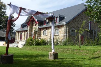 Miniature Location salle Libramont-Chevigny (Luxembourg) - Domaine du Château de Freux #8 Un couple en tenue de mariage se tient devant un officiant dans un décor festif avec sapins et guirlandes lumineuses.
