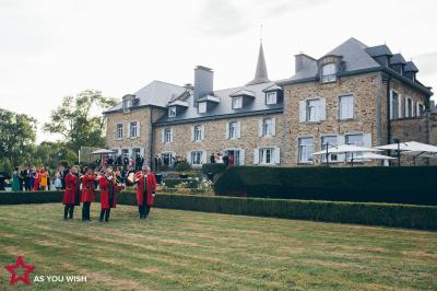 Miniature Location salle Libramont-Chevigny (Luxembourg) - Domaine du Château de Freux #2 Un couple en tenue de mariage se tient devant un officiant dans un décor festif avec sapins et guirlandes lumineuses.