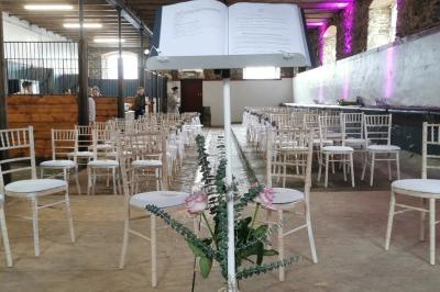 Miniature Célébration au rez de chaussée de la Salle Hermès Un couple en tenue de mariage se tient devant un officiant dans un décor festif avec sapins et guirlandes lumineuses.