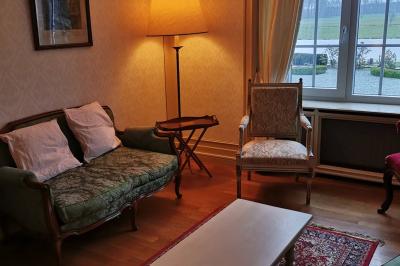 Miniature Petit salon du château Un couple en tenue de mariage se tient devant un officiant dans un décor festif avec sapins et guirlandes lumineuses.