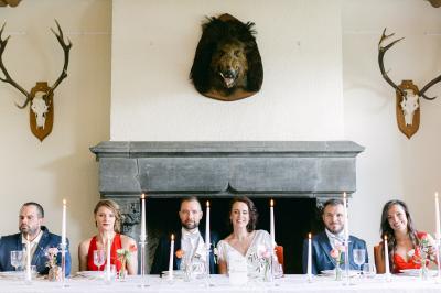 Miniature Salle à manger du château Un couple en tenue de mariage se tient devant un officiant dans un décor festif avec sapins et guirlandes lumineuses.