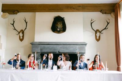 Miniature Salle à manger du château Un couple en tenue de mariage se tient devant un officiant dans un décor festif avec sapins et guirlandes lumineuses.