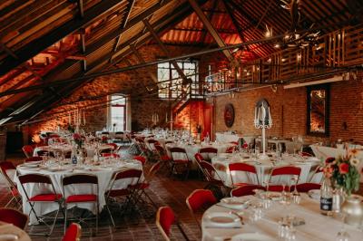 Miniature Salle Hermès Un couple en tenue de mariage se tient devant un officiant dans un décor festif avec sapins et guirlandes lumineuses.