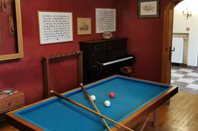 Miniature Salon billard au château Un couple en tenue de mariage se tient devant un officiant dans un décor festif avec sapins et guirlandes lumineuses.