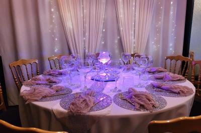 Miniature Silvie Wedding & Events #6 Figurines de mariés sur un gâteau décoré de fleurs bleues, d'une feuille argentée et d'un cœur en arrière-plan.