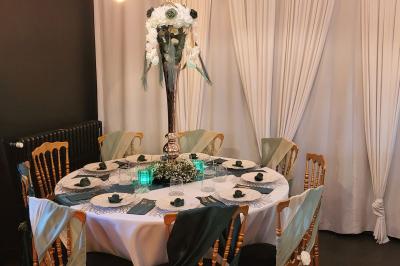 Miniature Silvie Wedding & Events #29 Figurines de mariés sur un gâteau décoré de fleurs bleues, d'une feuille argentée et d'un cœur en arrière-plan.