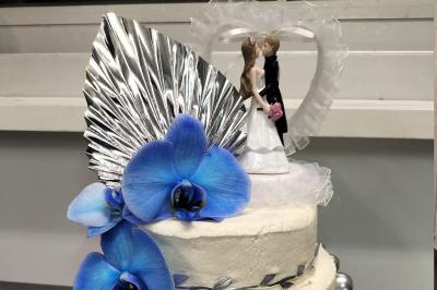 Miniature Silvie Wedding & Events #40 Figurines de mariés sur un gâteau décoré de fleurs bleues, d'une feuille argentée et d'un cœur en arrière-plan.