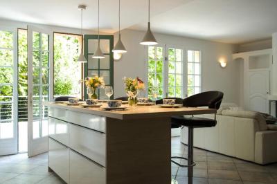 Salle de bain moderne avec lavabo, miroir éclairé, meuble de rangement et douche à paroi vitrée.