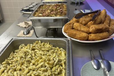 Lavabo moderne avec miroir, distributeur de savon mural et carrelage beige dans une salle de bain.