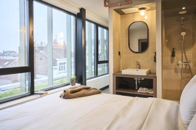 Lavabo moderne avec miroir, distributeur de savon mural et carrelage beige dans une salle de bain.