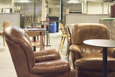 Lavabo moderne avec miroir, distributeur de savon mural et carrelage beige dans une salle de bain.