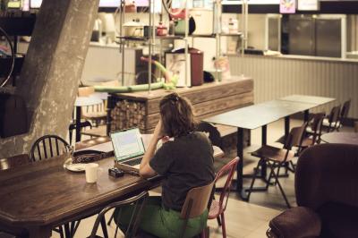 Lavabo moderne avec miroir, distributeur de savon mural et carrelage beige dans une salle de bain.