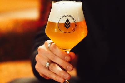 Lavabo moderne avec miroir, distributeur de savon mural et carrelage beige dans une salle de bain.