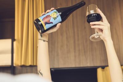 Lavabo moderne avec miroir, distributeur de savon mural et carrelage beige dans une salle de bain.