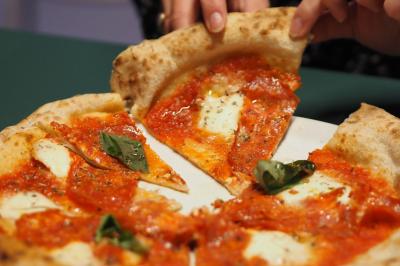 Lavabo moderne avec miroir, distributeur de savon mural et carrelage beige dans une salle de bain.