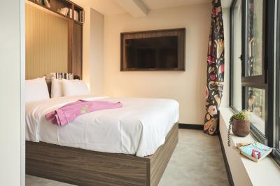 Miniature Location salle Lille (Nord) - Jost #33 Lits superposés en bois avec rideaux jaunes dans une chambre lumineuse, échelle et fenêtres sur le côté.