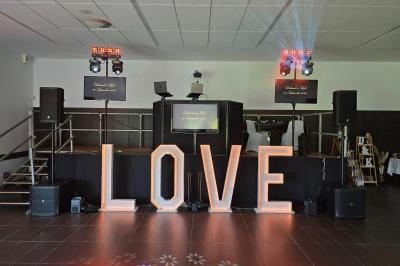 Miniature DJ La Chapelle-Lasson (Marne) - DJ Asanime #2 Salle de réception décorée pour un événement, avec tables rondes dressées, nappes blanches et éléments végétaux.