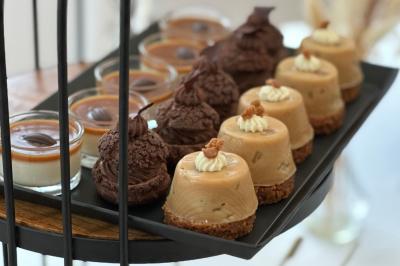 Miniature Traiteur Magny-les-Hameaux (Yvelines) - Lars Traiteur #14 Gâteau de fête décoré de bougies scintillantes, entouré de desserts et de convives en arrière-plan flou.