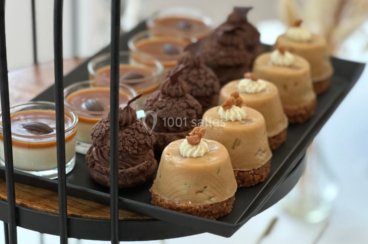 Plateau de desserts variés comprenant des entremets au caramel, des choux au chocolat et des crèmes dessert.